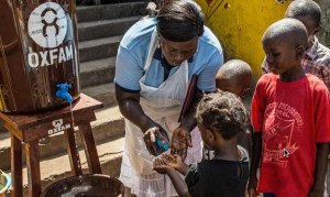 Community health worker Marrion Thomson teaches children how to wash their hands 