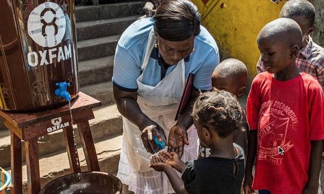 Community health worker Marrion Thomson teaches children how to wash their hands