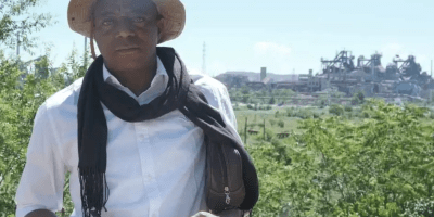 Robert Dissa poses in front of the Azovstal metallurgical plant in Mariupol, Ukraine