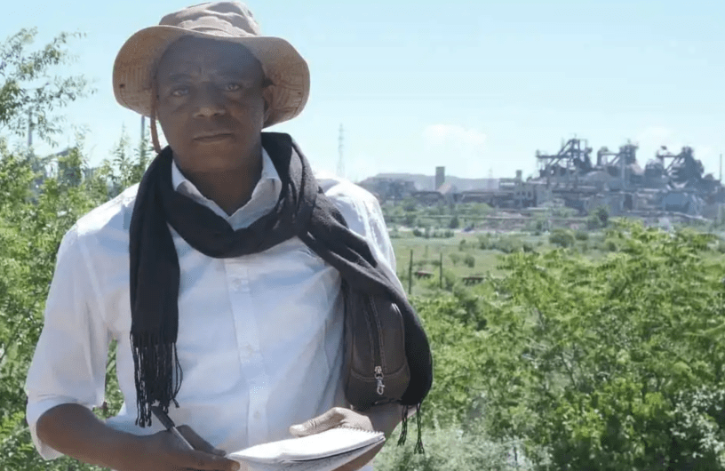 Robert Dissa poses in front of the Azovstal metallurgical plant in Mariupol, Ukraine