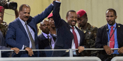 Eritrean President Isaias Afwerki and Ethiopian Prime Minister Abiy Ahmed, center, raise arms together in celebration before a crowd in Addis Ababa, Ethiopia, July 15, 2018
