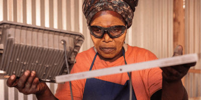 The owner of a Langa food stall holding her panel